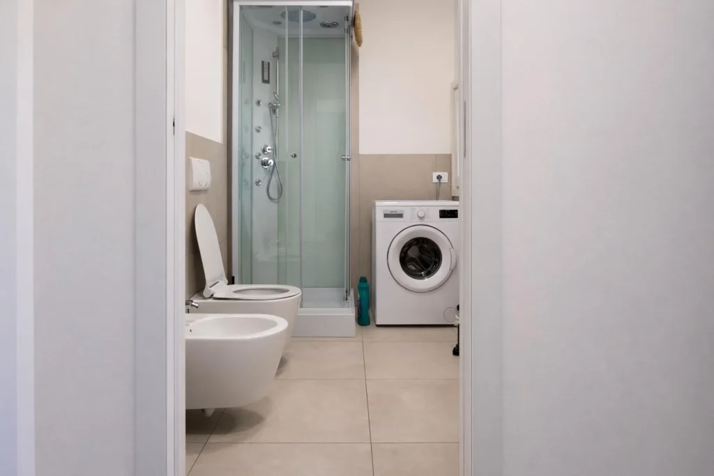Bagno moderno con doccia, bidet, wc e lavatrice bianca
