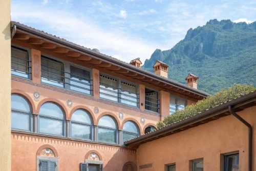 Facciata esterna con finestre ad arco e montagna sullo sfondo
