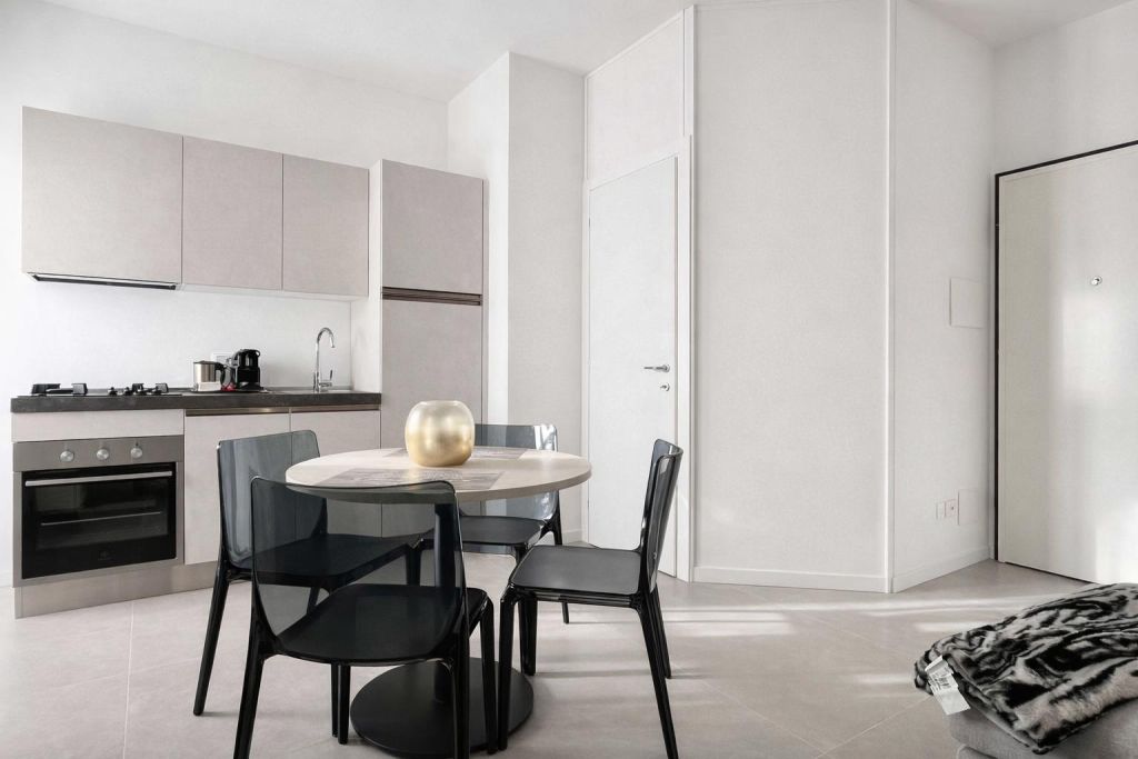Cucina moderna con tavolo rotondo e quattro sedie nere trasparenti