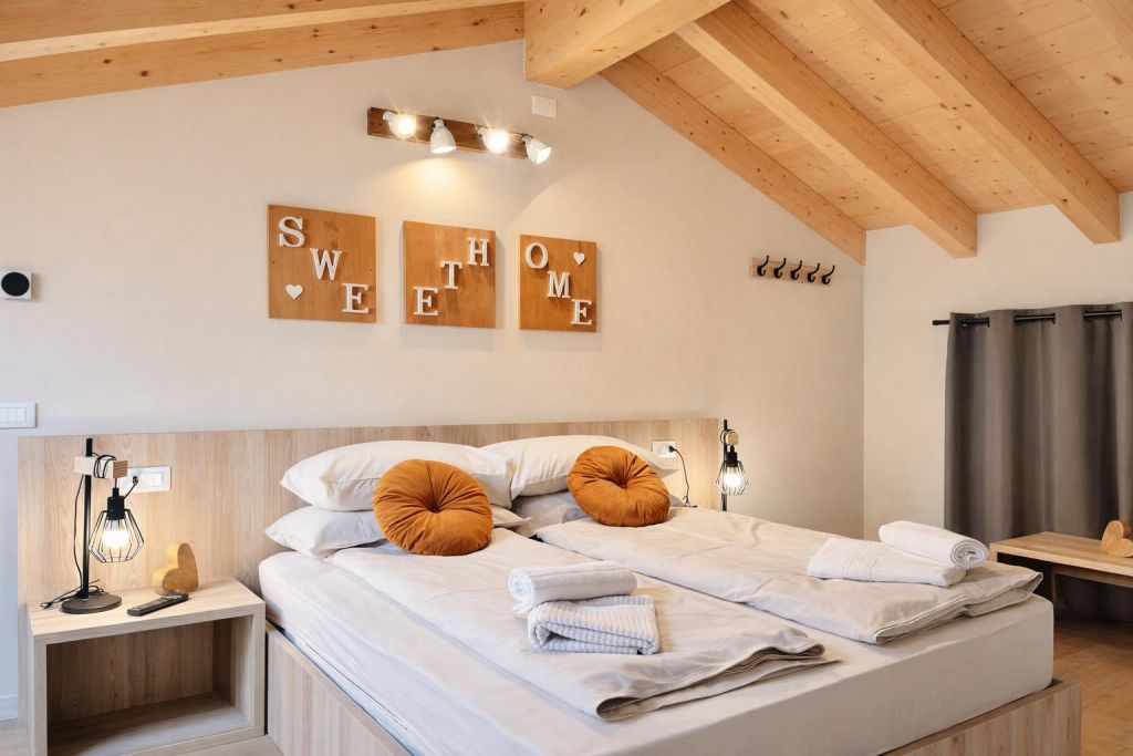 Camera da letto con letto matrimoniale, cuscini rotondi arancioni e travi in legno a vista