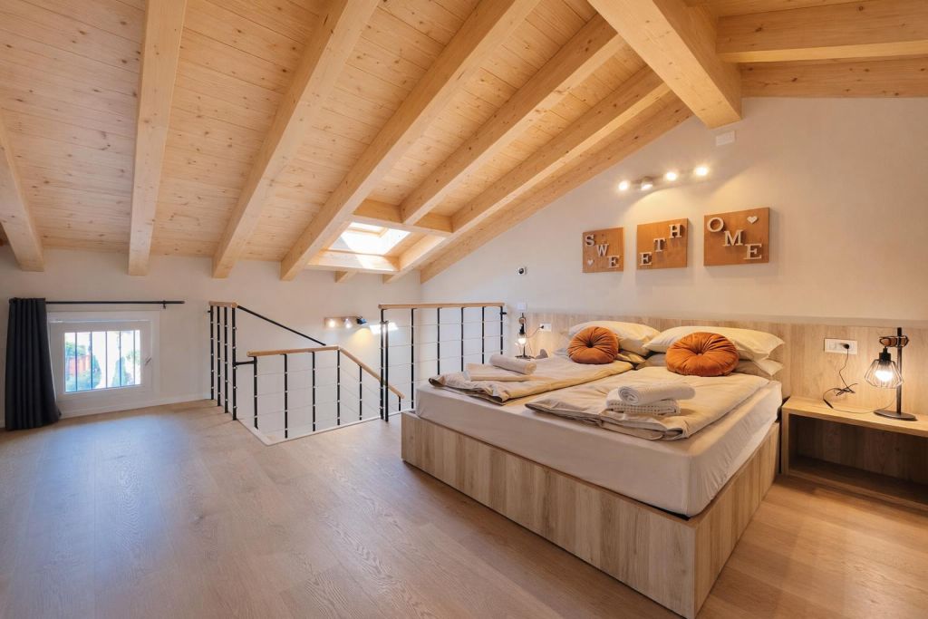 Camera mansardata con Bett matrimoniale, travi in legno e finestra sul pavimento